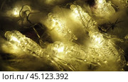 Transparent skeletons glowing yellow, close-up. Transform your space with a whimsical garland featuring glowing skeleton skulls and bones, perfect for Halloween festivities and ambiance. Horror theme. Стоковое видео, видеограф Юлия Петровская / Фотобанк Лори
