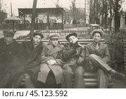 Молодые люди сидят на скамейке в начале 1960-х годов. Стоковое фото, фотограф Retro / Фотобанк Лори