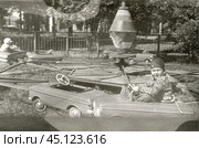 Мальчик катается на карусели с машинками в 1960-е годы. Стоковое фото, фотограф Retro / Фотобанк Лори