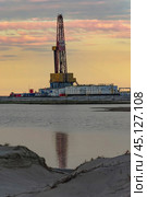 Drilling oil and gas wells in desert terrain. Sand hills, sparse vegetation. Beautiful sky. Infrastructure of the drilling rig. Стоковое фото, фотограф Владимир Ендовицкий / Фотобанк Лори
