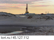Drilling oil and gas wells in desert terrain. Sand hills, sparse vegetation. Beautiful sky. Infrastructure of the drilling rig. Стоковое фото, фотограф Владимир Ендовицкий / Фотобанк Лори