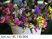 Bouquet of multicolored flowers in a vase (Limonium sinuatum, Statice sinuata) on a green background. Стоковое фото, фотограф Ирина Вершинская / Фотобанк Лори