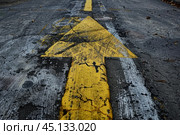Yellow arrow sign pointing up on deteriorated asphalt road. Стоковое AI-изображение, AI-художник Иван Рябоконь / Фотобанк Лори