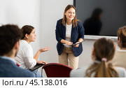 Competent female tutor teaching students in college classroom. Стоковое фото, фотограф Яков Филимонов / Фотобанк Лори
