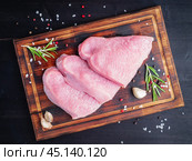 Turkey steak, raw fillet on chopping board on dark background, meat with. Стоковое фото, фотограф Natalia Gdovskaia / Фотобанк Лори
