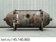 Old rusty industrial autoclave tank standing outdoors. Стоковое AI-изображение, AI-художник Иван Рябоконь / Фотобанк Лори