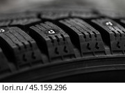 Close up photo of a brand new studded tire with metal studs. Стоковое фото, фотограф EugeneSergeev / Фотобанк Лори