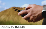 a surveyor on a construction site controls a quadcopter. Стоковое видео, видеограф Igor Skripachev / Фотобанк Лори