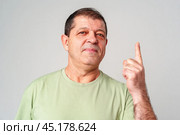 A man in a light green shirt raises his finger, signifying an important message. Стоковое фото, фотограф Сергей Толмачёв / Фотобанк Лори