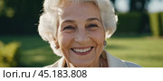 Sophisticated smiling older French woman in the open air. Demeanor reveals a lifetime of experiences and reflections, embodying grace and wisdom. Well-groomed woman 70 years old with grey hair. AI. Стоковое AI-изображение, AI-художник Юлия Петровская / Фотобанк Лори
