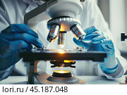 Close-up of the scientist's hands at the microscope lens during biological research. The concept of scientific research. Стоковое AI-изображение, AI-художник Ярославский Максим / Фотобанк Лори