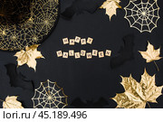 The inscription happy Halloween. Modern background with black bats, Golden leaves, cobwebs and wooden letters. Halloween with copy space for text. Flat lay, top. Стоковое фото, фотограф Photojuli / Фотобанк Лори