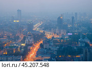 Город Екатеринбург, Свердловская область, Россия. Вид сверху на большой город. Красивый вечерний городской пейзаж. Общий вид в сумерках на улицы, дома и церкви. Вдали в дымке высотные здания. (2023 год). Стоковое фото, фотограф Андрей Степанов / Фотобанк Лори
