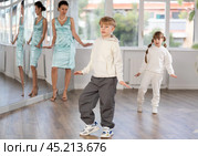Tween boy mimicking comedic stroll of Charlie Chaplin during dance rehearsal. Стоковое фото, фотограф Яков Филимонов / Фотобанк Лори