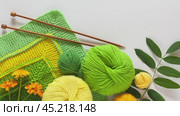Video of hand knitting square pattern using 10-stitch method from yarn of green and yellow wool on white backgroung. Summer needlework. DIY concept. Top view, flat lay, closeup, mock up. Стоковое видео, видеограф Виктория Катьянова / Фотобанк Лори