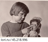 Портрет маленькой девочки с игрушечной куклой. Старая чёрно-белая фотография 1966 года. Редакционная иллюстрация, иллюстратор александр афанасьев / Фотобанк Лори