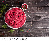 Mince beef, ground meat with ingredients for cooking on dark blue. Стоковое фото, фотограф Natalia Gdovskaia / Фотобанк Лори