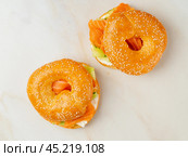 Two sandwiches with salmon, cream cheese, cucumber slices on white marble table. Стоковое фото, фотограф Natalia Gdovskaia / Фотобанк Лори