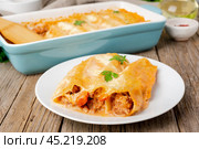Cannelloni with filling of ground beef, tomatoes, baked with bechamel tomato sauce, side view, old dark wooden background. Стоковое фото, фотограф Natalia Gdovskaia / Фотобанк Лори