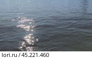 Почти ровная поверхность воды. Небольшое волнение на открытом водоеме. волны плавно перетекают друг в друга. ВОда темно коричневого цвета, от ее поверхности отражаются лучи солнца. Стоковое видео, видеограф Andrew_Swarga / Фотобанк Лори