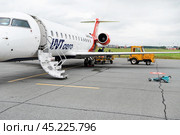 Gorno-altaisk airport, Russia-23.08.2024: Small regional jet UVT aero with passengers on airport tarmac under clear sky. Стоковое фото, фотограф Вербицкая Светлана / Фотобанк Лори
