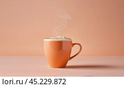 Minimalist coffee cup on peach fuzz colored table. Cup of coffee in Peach Fuzz color. side view, banner. color of year 2024. Peach Fuzz cup of cappuccino coffee. Стоковое AI-изображение, AI-художник Павел Муравьев / Фотобанк Лори