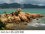 Nha Trang Vietnamese resort coastline is revealed in vibrant spectacle. picturesque rocky coast meet azure sea under radiant sun, panorama of beaches and crystal-clear waters. Стоковое фото, фотограф Павел Муравьев / Фотобанк Лори