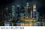 Night Singapore, Marina Bay comes alive with dazzling glow of skyscrapers. cityscape is adorned with vibrant lights, creating mesmerizing spectacle of urban modernity. Редакционное фото, фотограф Павел Муравьев / Фотобанк Лори