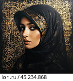 Woman wearing traditional hijab with exquisite gold patterns. In the background, you can see Arabic calligraphy, also in gold, which gives the image a luxurious and culturally significant look. The woman's face expresses calm and confidence, and her gaze is directed to the side, creating a sense of depth and emotional involvement. The photo can be used for themes related to culture, religion, art and fashion. Стоковое AI-изображение, AI-художник Анна Кривицкая / Фотобанк Лори