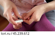 Mother use Nail Trimmer with baby hand. Mom cutting tiny fingernails. Baby care concept. How to successfully clip your babys nails. Closeup. Newborn hygiene. Clipping Childs Nails. Front view. Стоковое видео, видеограф Марина Демидюк / Фотобанк Лори