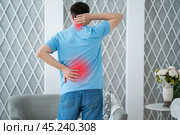 Back and neck pain, lumbar and cervical spine hernia, man with backache at home. Стоковое фото, фотограф Станислав Тарко / Фотобанк Лори