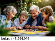 A grandparents playing board games with their grandchildren in outdoors, the joy of intergenerational communication, selective focus, shallow depth of field. Стоковое AI-изображение, AI-художник Михаил Строгалев / Фотобанк Лори