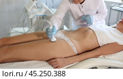 Young woman undergoing phonophoresis procedure on anterior thighs using high-frequency ultrasound attachment in cosmetic clinic. Modern hardware cosmetology. Стоковое видео, видеограф Яков Филимонов / Фотобанк Лори