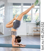 Young woman practicing vinyasa yoga in studio. Стоковое фото, фотограф Яков Филимонов / Фотобанк Лори