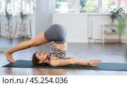 Young woman practicing vinyasa yoga in studio. Стоковое фото, фотограф Яков Филимонов / Фотобанк Лори