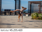 A young woman in a tracksuit performs physical exercises in a summer park. Стоковое фото, фотограф Андрей Аркуша / Фотобанк Лори