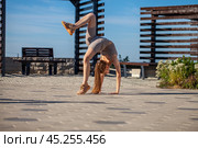 A young woman in a tracksuit performs physical exercises in a summer park. Стоковое фото, фотограф Андрей Аркуша / Фотобанк Лори