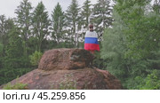 The Russian flag is on the shoulders of a girl standing against the backdrop of the Caucasus mountains. Unity Day in Russia. Стоковое видео, видеограф Екатерина Золина / Фотобанк Лори