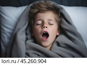 cold tones, boy in t shirt lied in bed under blanket and yawns or very emotional expression sings songs with wide opened mouth and squint eyes. Стоковое AI-изображение, AI-художник Sergey Grishin / Фотобанк Лори