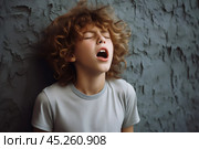 Young boy standing in front of wall, whim, looking up with surprised and state of shock or confusion, he heard or seen something unexpected or terrible. He very emotional expression sings songs. Стоковое AI-изображение, AI-художник Sergey Grishin / Фотобанк Лори