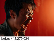 Expression of furious,enraged asian man with grumpy grimace on his face,with mouth opened in shout, ready to argue and swear, wants to gain respect, show strength, isolated over red background. Стоковое AI-изображение, AI-художник Sergey Grishin / Фотобанк Лори