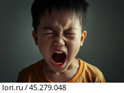 Portrait of Asian angry, sad and cry little boy on dirty grey color background, The emotion of a child when tantrum and mad, expression grumpy emotion, yelling, shouting. Kid emotional control concept. Стоковое AI-изображение, AI-художник Sergey Grishin / Фотобанк Лори