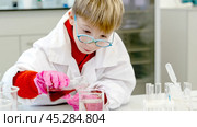 a student in a chemical laboratory conducts chemical sweats with chemical elements. Стоковое фото, фотограф Igor Skripachev / Фотобанк Лори