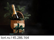 Christmas holiday gift hamper with sparkling wine and gift on black. Стоковое фото, фотограф Светлана Лажко / Фотобанк Лори