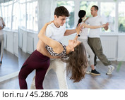 Happy couples young male and female dancing samba in dance room during training. Стоковое фото, фотограф Яков Филимонов / Фотобанк Лори