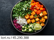 Colorful fresh salad ingredients arranged in a bowl with lime and herbs on a dark surface. Стоковое AI-изображение, AI-художник Юлия Гапеенко / Фотобанк Лори