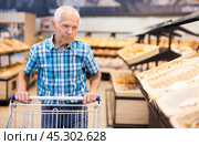 Mature senor choosing bread and baking in grocery section of supermarket. Стоковое фото, фотограф Татьяна Яцевич / Фотобанк Лори