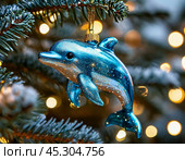 A cheerful dolphin hangs on a Christmas tree, a bright Christmas tree toy. New Year's decor. Festive New Year's atmosphere. Стоковое AI-изображение, AI-художник Сергей Елизарьев / Фотобанк Лори