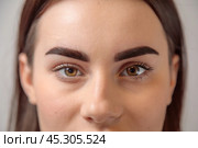 Beautician showing perfect eyebrows after permanent makeup treatment. Стоковое фото, фотограф Юрий Поздников / Фотобанк Лори