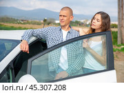 Positive young couple talking near car on spring day. Стоковое фото, фотограф Яков Филимонов / Фотобанк Лори
